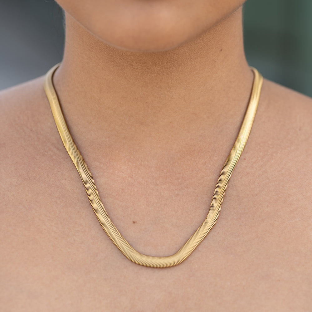 Gold necklace on a person with a blurred background