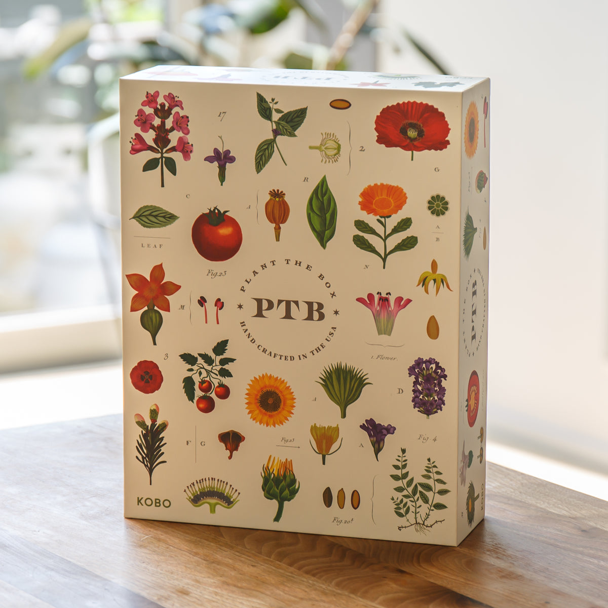 Kobo plantable product packaging with colorful botanical illustrations on a wooden surface.