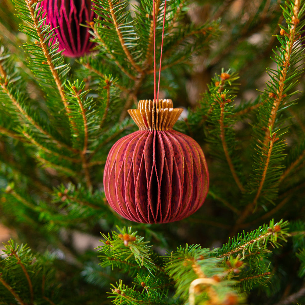 Decorative paper ornament with a string on a white background