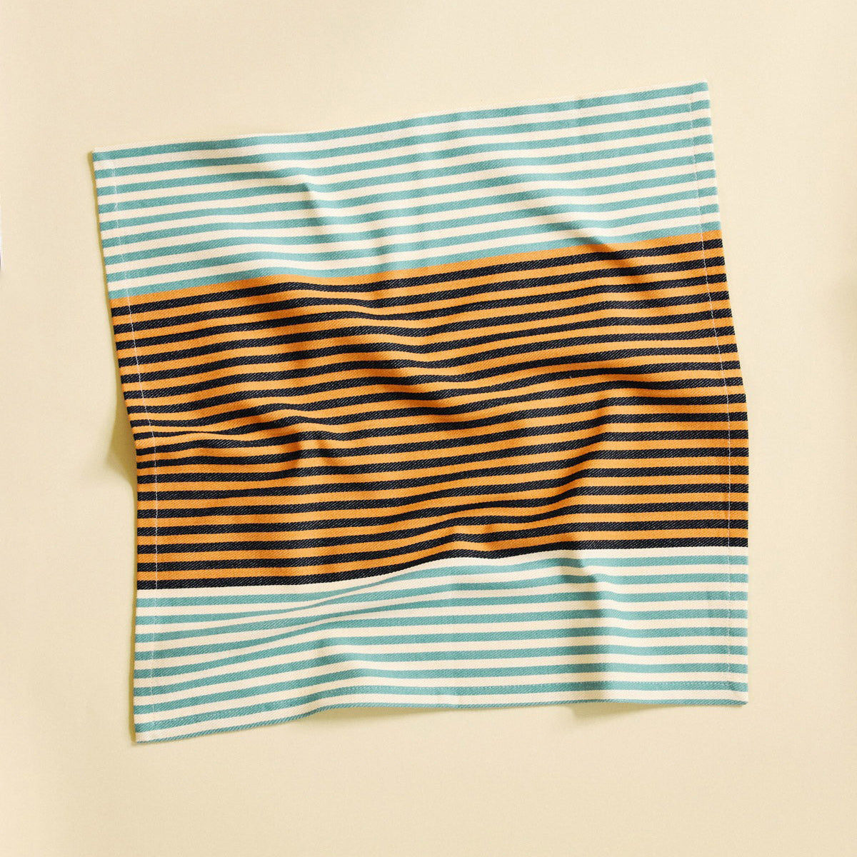 Striped fabric with blue, orange, and black stripes on a beige background