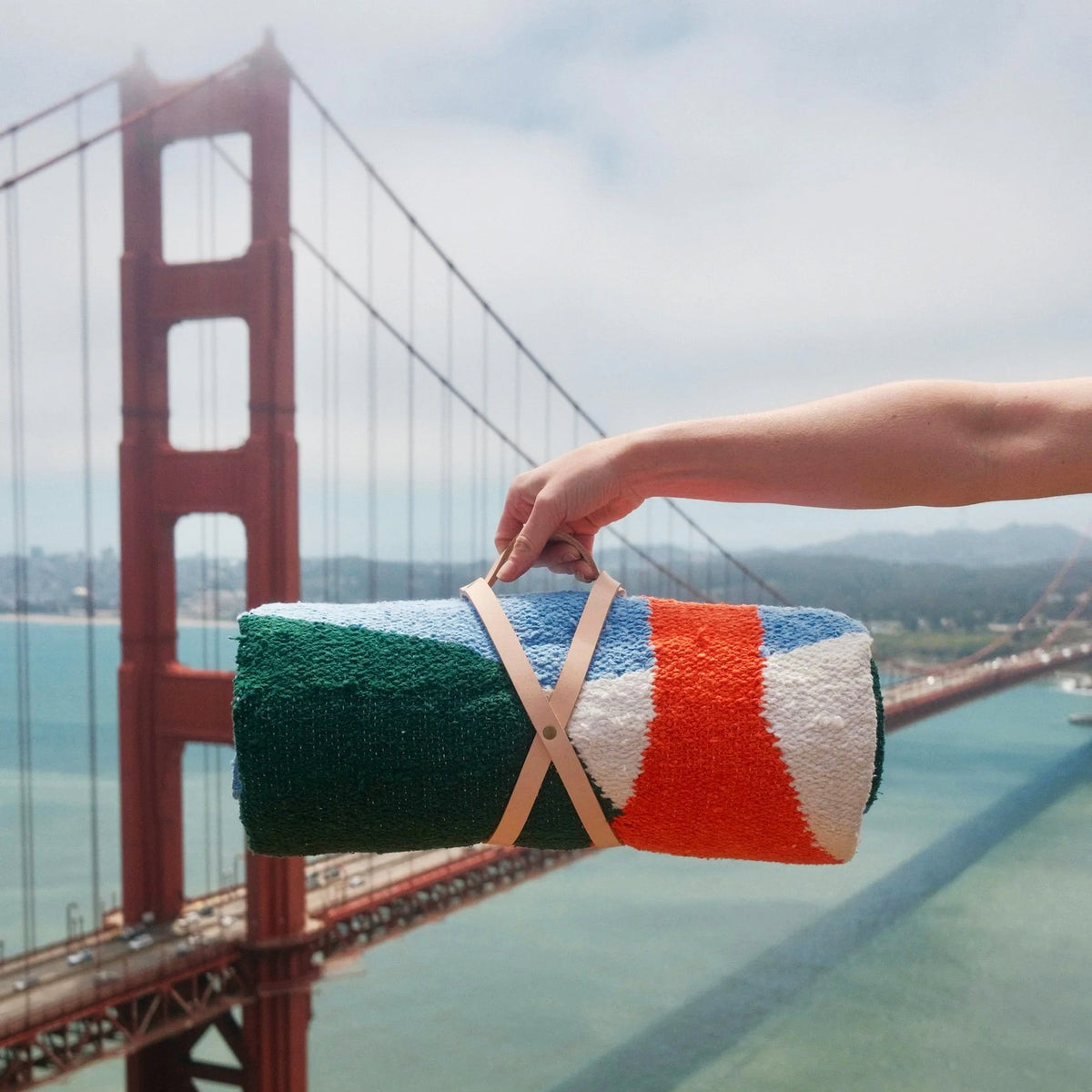 Rolled blanket held in front of the Golden Gate Bridge