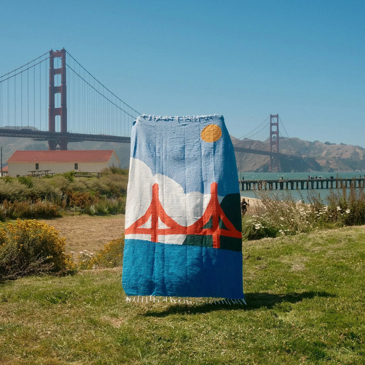 Blanket with Golden Gate Bridge design in front of the Golden Gate Bridge