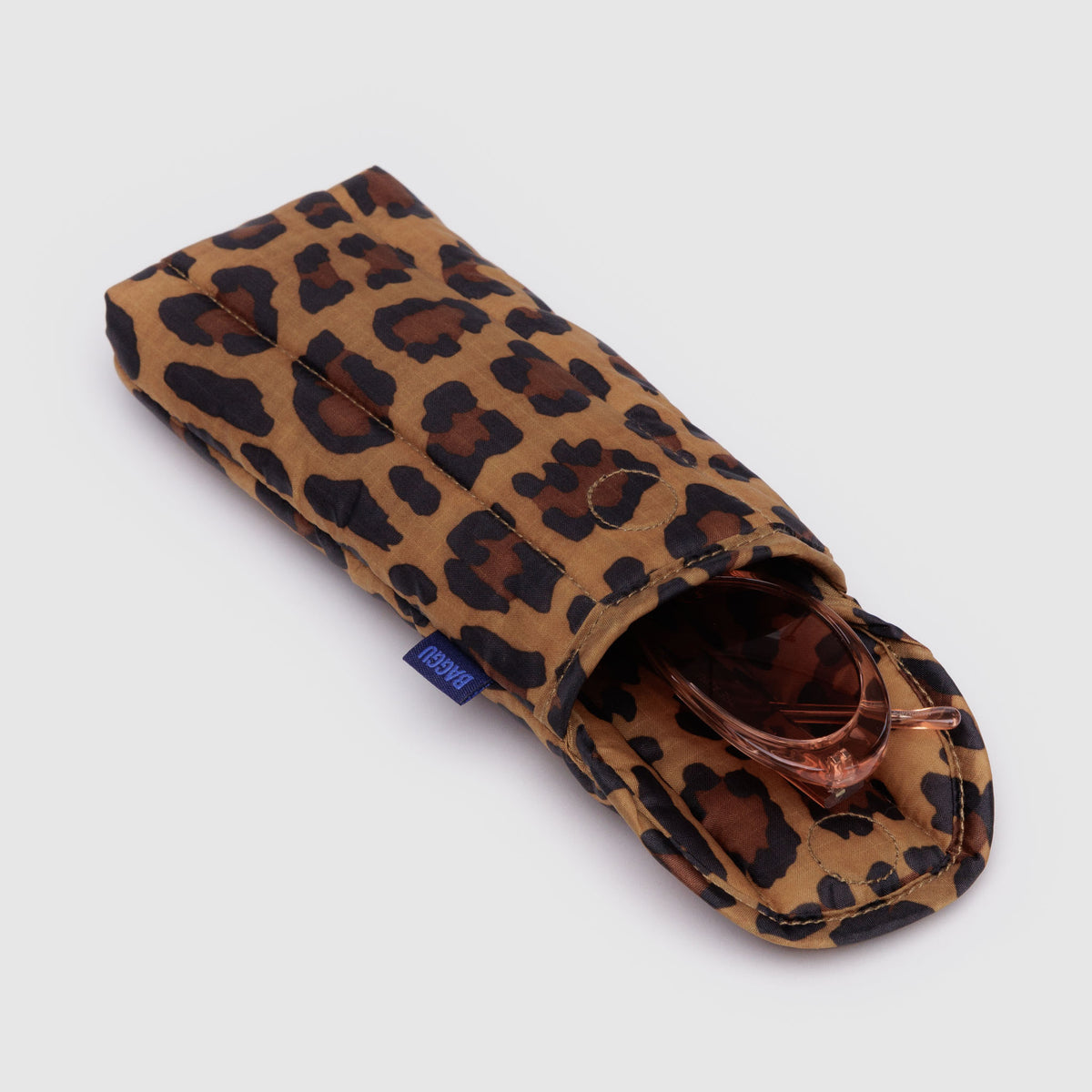 Leopard print sunglasses case with sunglasses inside on a light gray background
