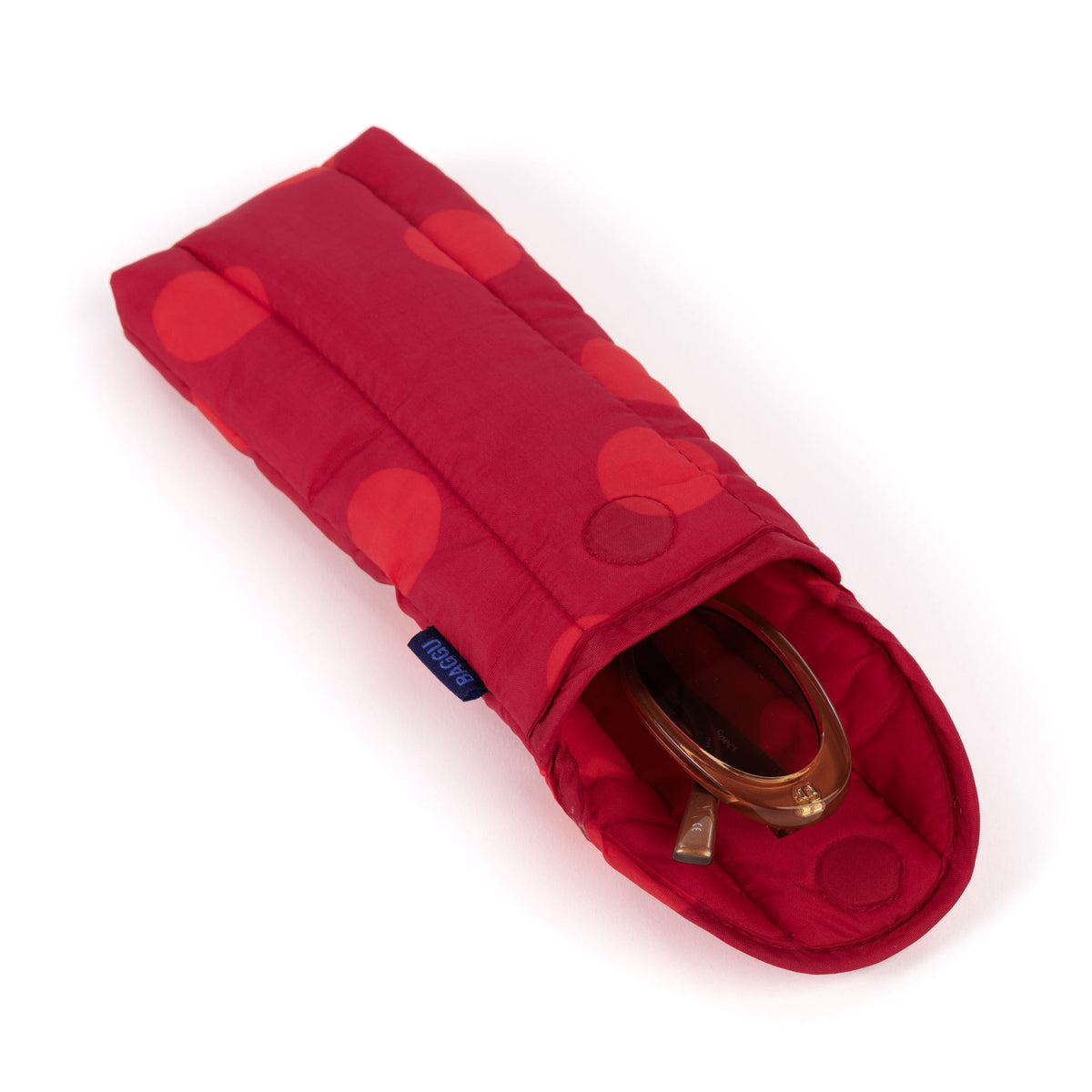 A red padded fabric pouch with a polka-dot pattern, shown open on a white background with a pair of sunglasses inside.