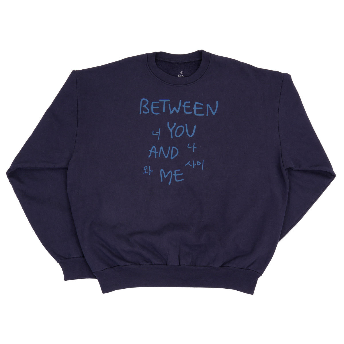A navy blue crewneck sweatshirt with light blue text on the front reading 'BETWEEN YOU AND ME' in English and Korean, laid flat on a white background.