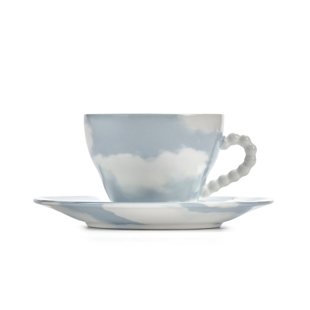A delicate ceramic teacup and saucer set with a sky-blue and white cloud pattern, featuring a textured beaded handle on the cup, set against a solid white background.