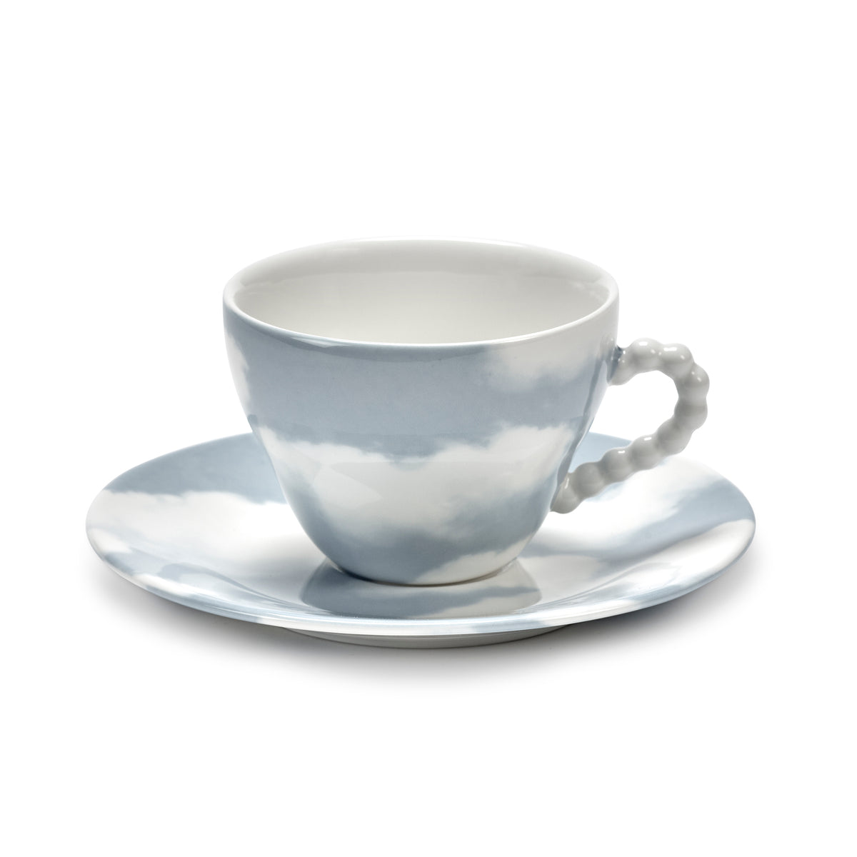 A white porcelain teacup and saucer set with a sky-blue cloud pattern, featuring a textured beaded handle on the cup, set against a plain white background.