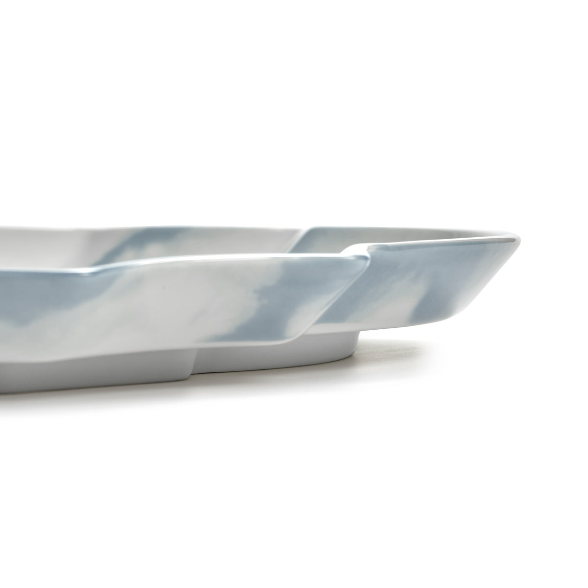 A close-up side view of a shallow rectangular dish or tray with a glossy white and light blue marbled finish, set against a plain white background.