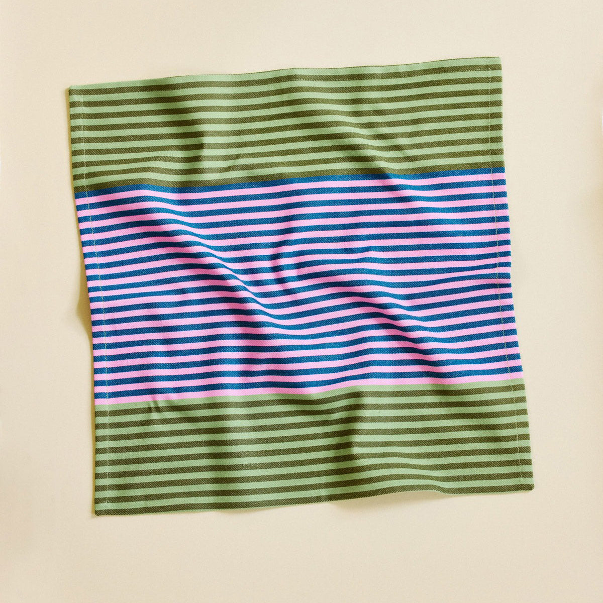 Striped fabric with green, pink, and blue colors on a beige background