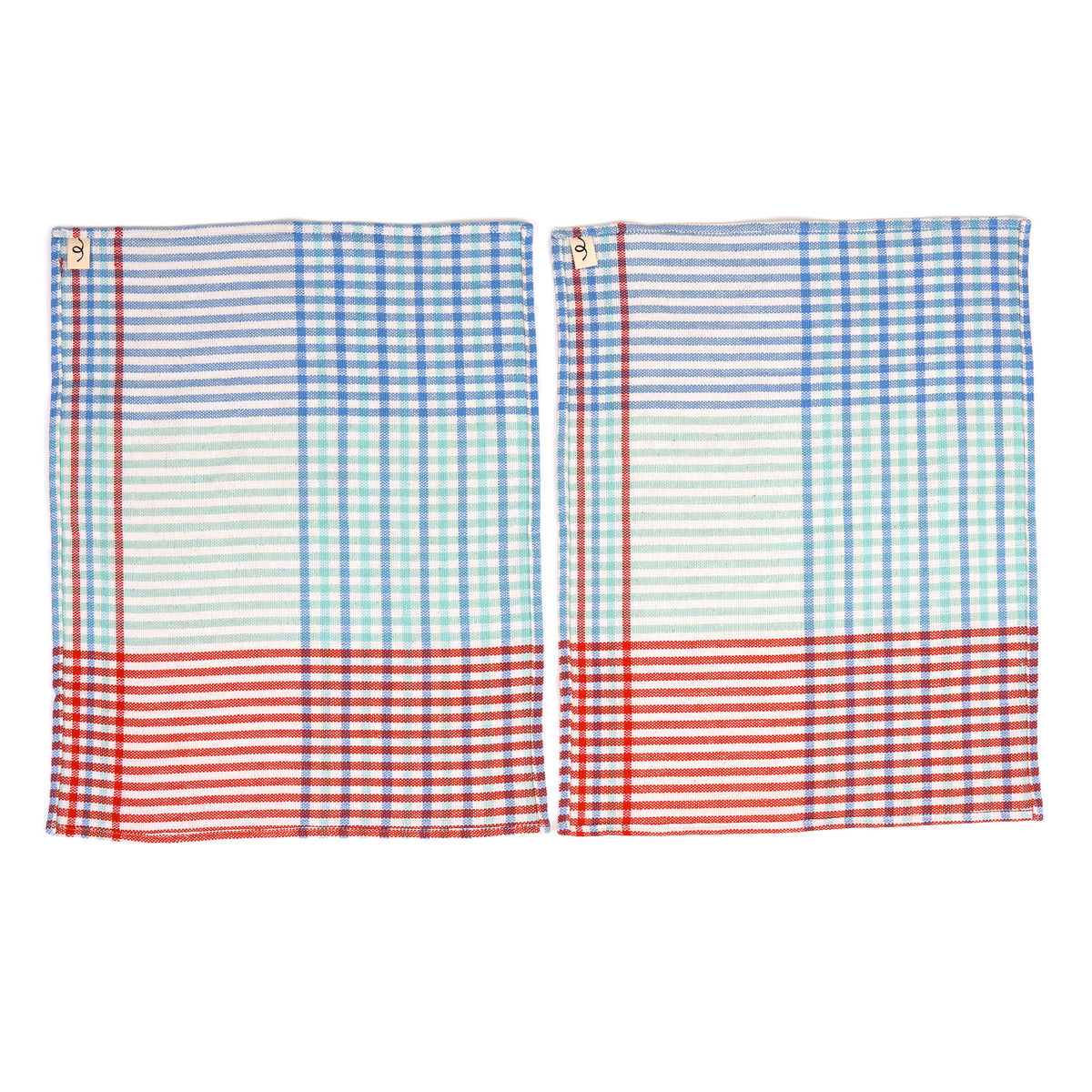 Two matching plaid placemats with a red, white, and blue checkered pattern, displayed side-by-side on a white background.