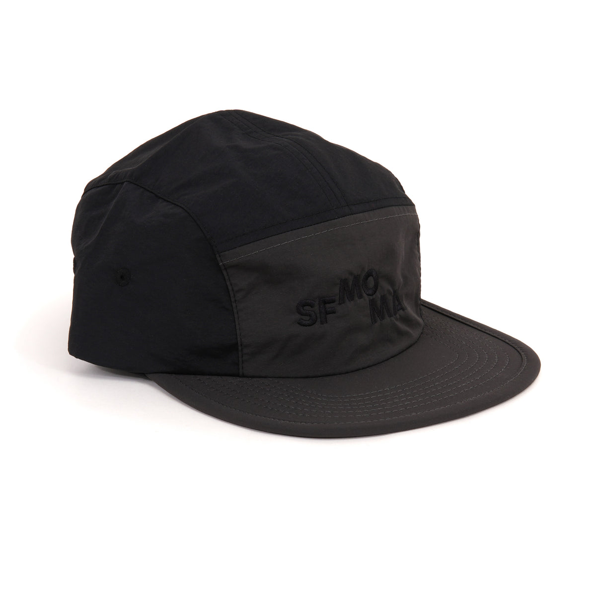 A black five-panel camp cap with a matching flat brim and tonal embroidered 'SF-MOMA' logo on the front, shown on a clean white background.