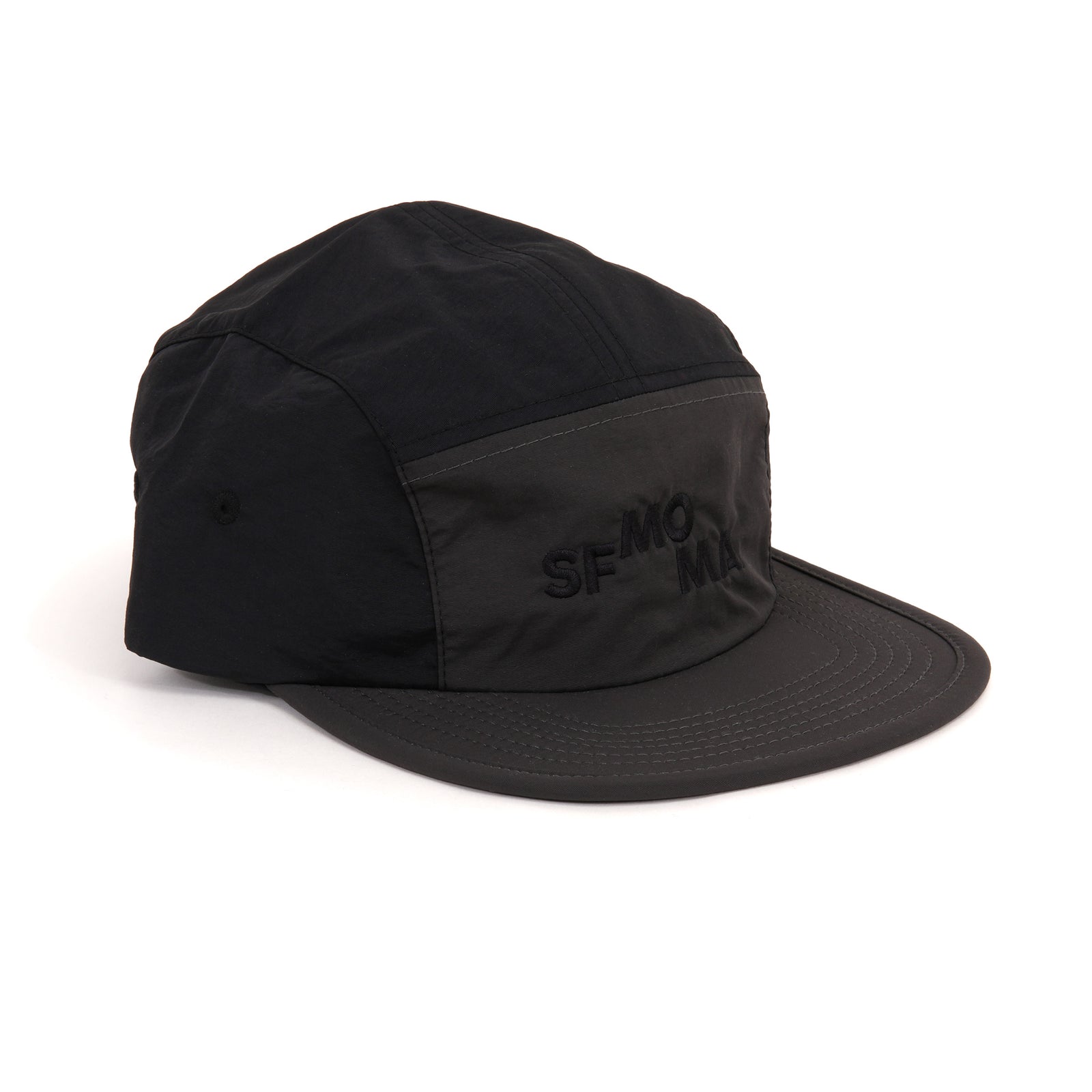 A black five-panel camp cap with a matching flat brim and tonal embroidered 'SF-MOMA' logo on the front, shown on a clean white background.