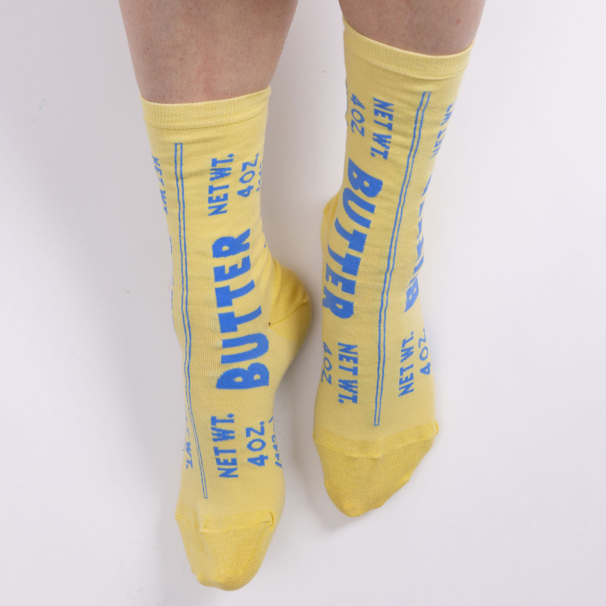 Yellow socks with blue text resembling butter packaging on a white background
