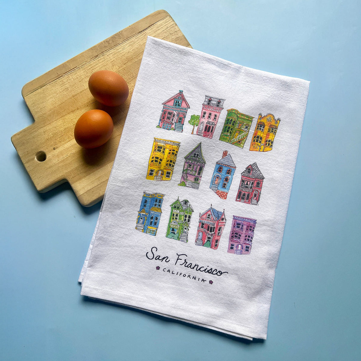 White towel with colorful house illustrations and 'San Francisco, California' text on a white background