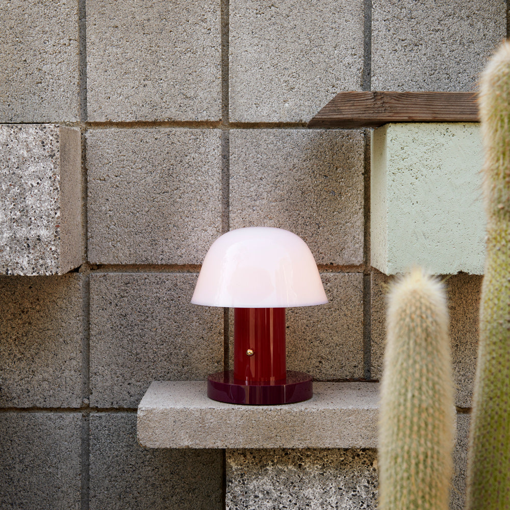 Portable lamp on concrete shelf.