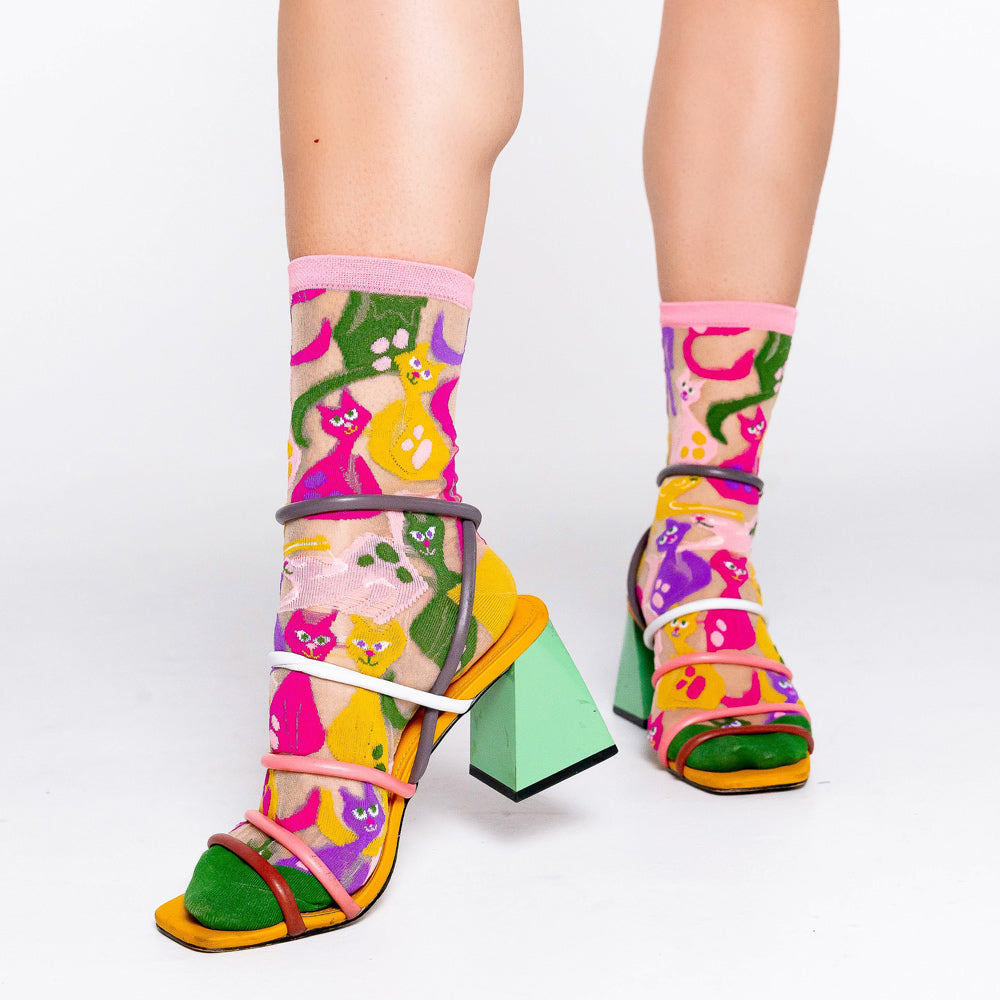 Model wearing socks with colorful heeled sandals.