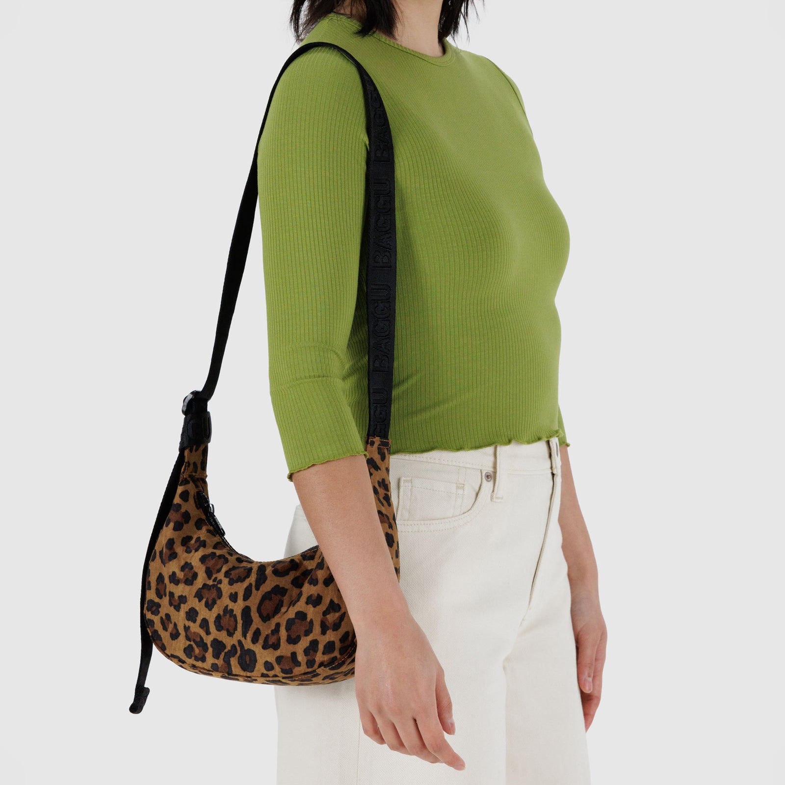 Leopard print handbag with a black strap on a white background