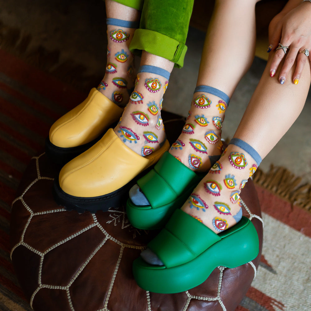 Two models wearing socks with clogs.