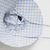 BAGGU Sun Hat in Sky Blue Pixel Gingham print. Drawstrings coming out from underneath.