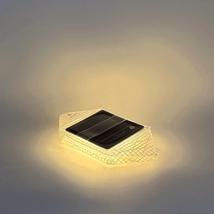 Solar panel light fixture emitting a warm glow on a gray background