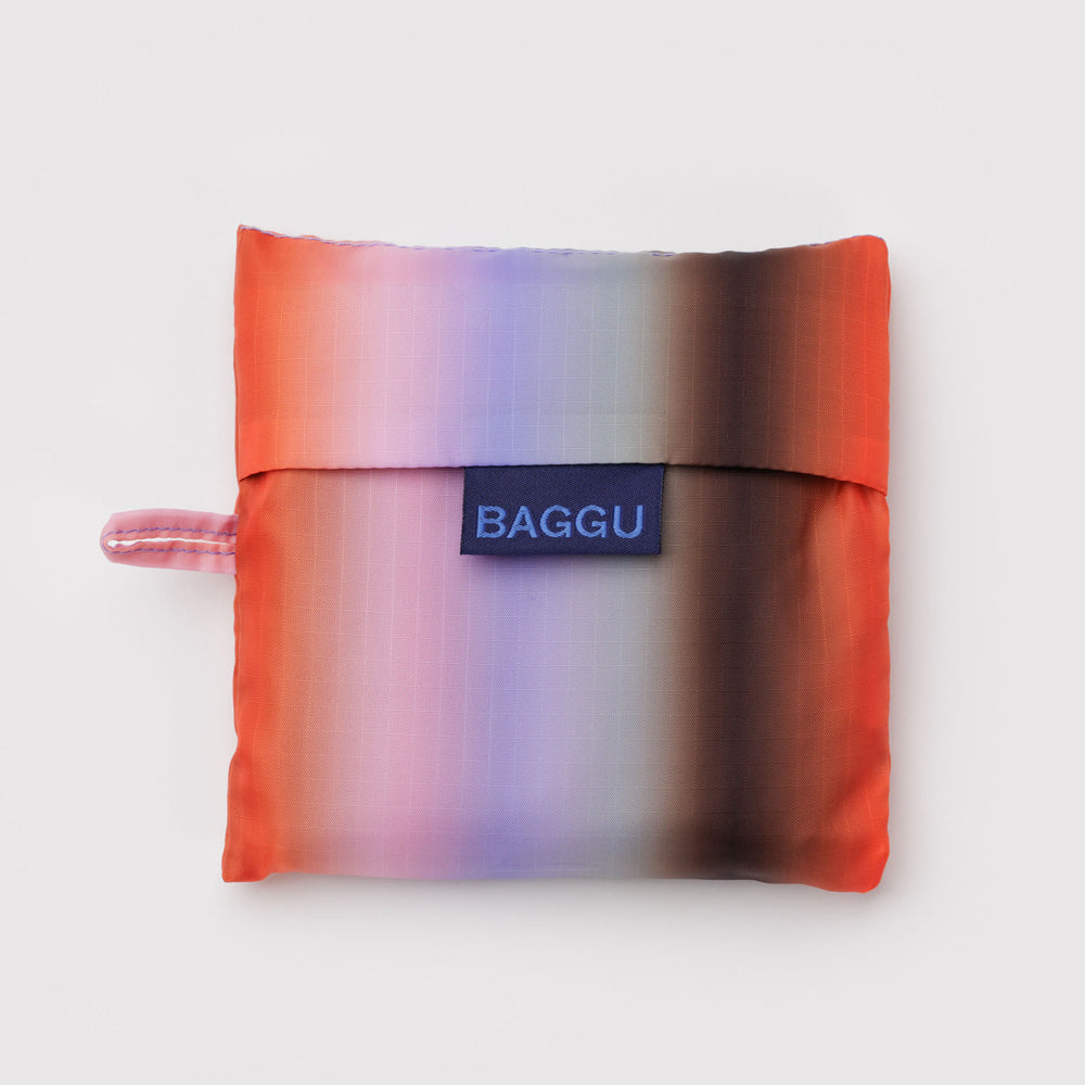 Gradient reusable bag with 'BAGGU' logo on a light gray background