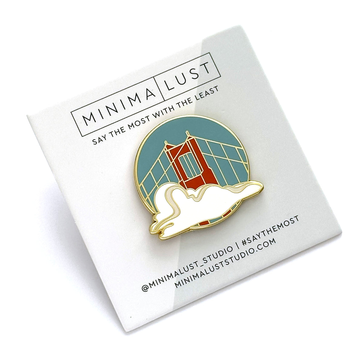 Enamel pin of a bridge design on a white card with 'MINIMALUST' branding.