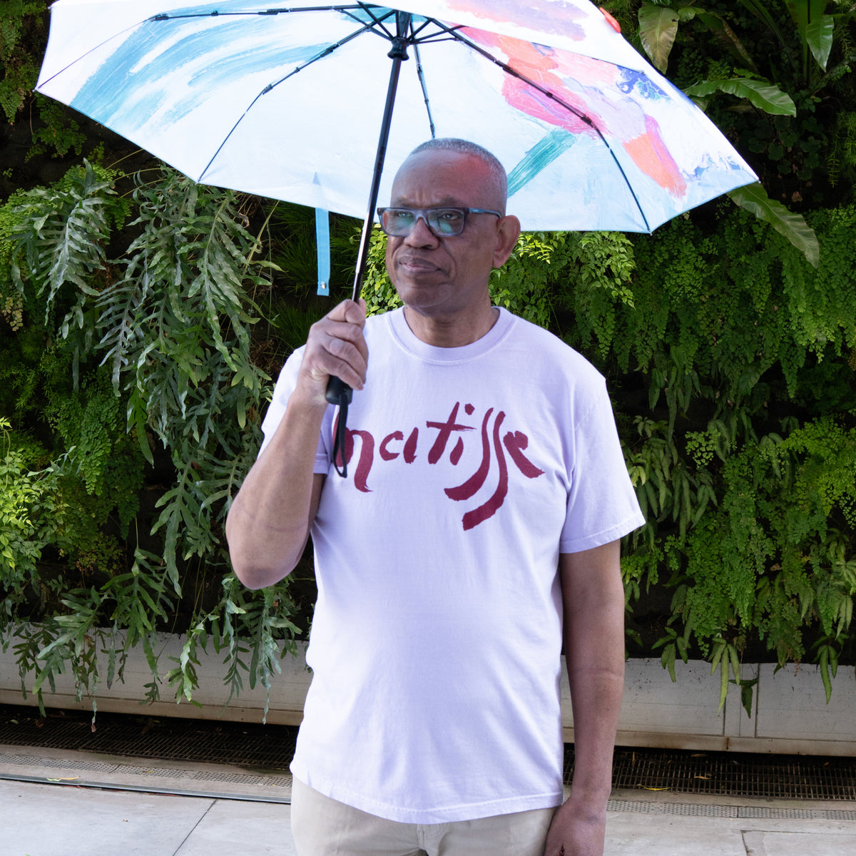 Matisse Exhibition T-Shirt and umbrella on a model in front of a living wall