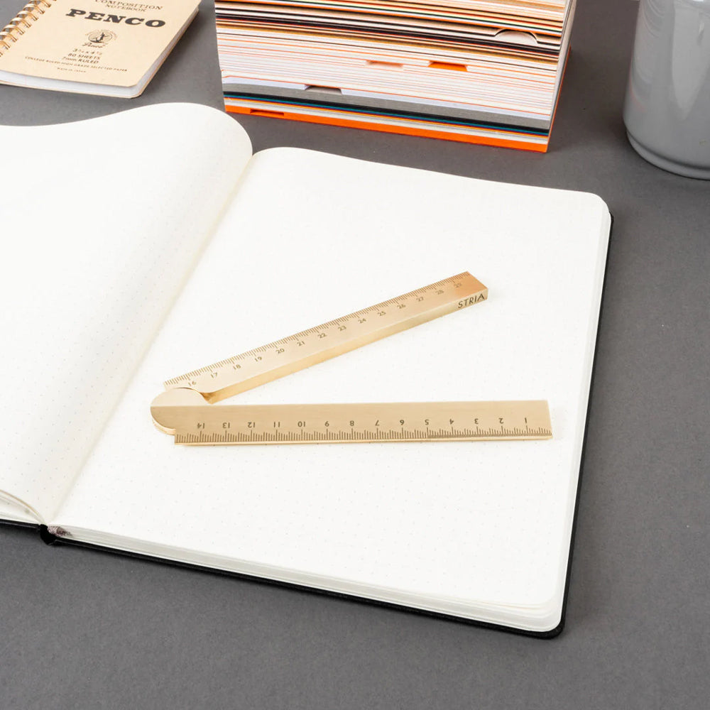 Open notebook with a folding ruler on a gray surface