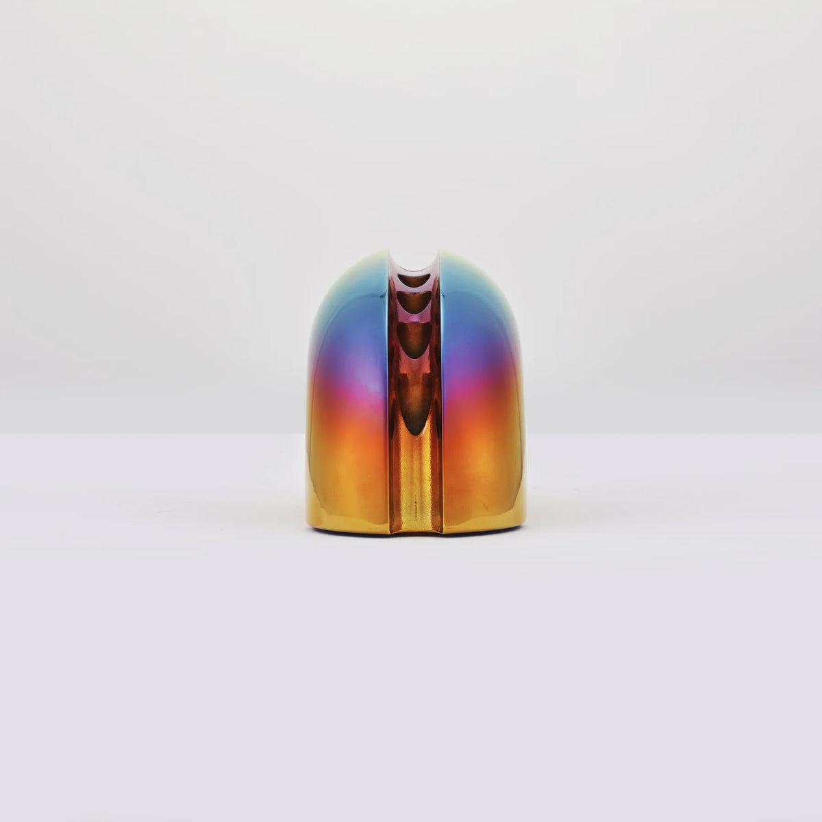 Side view menorah with iridescent rainbow finish, standing upright on a white surface against a white background.