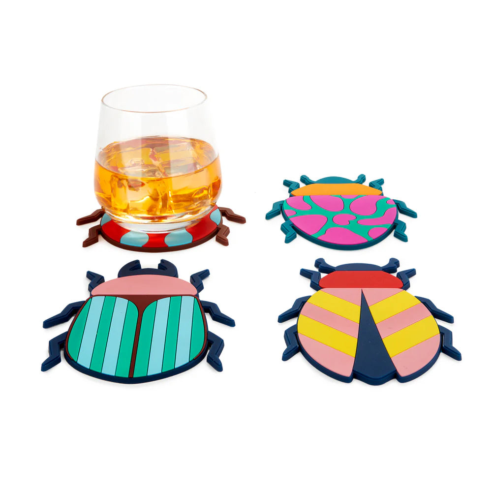 Colorful beetle-shaped coasters with a glass of orange liquid on a white background