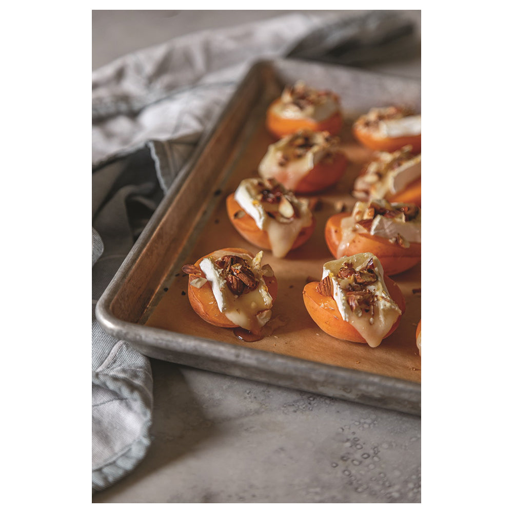 Photo of stuffed apricots on sheet pan.