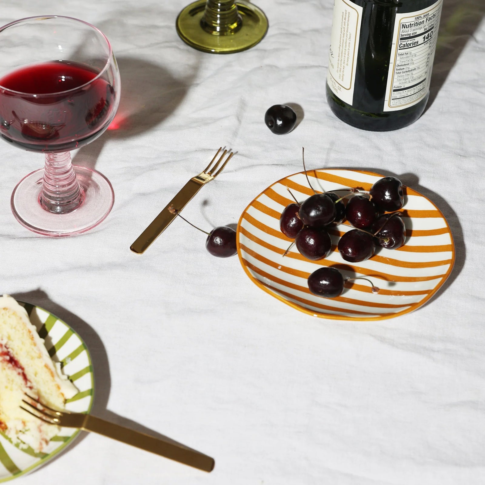 Four colorful small ceramic plates with striped patterns on a white background