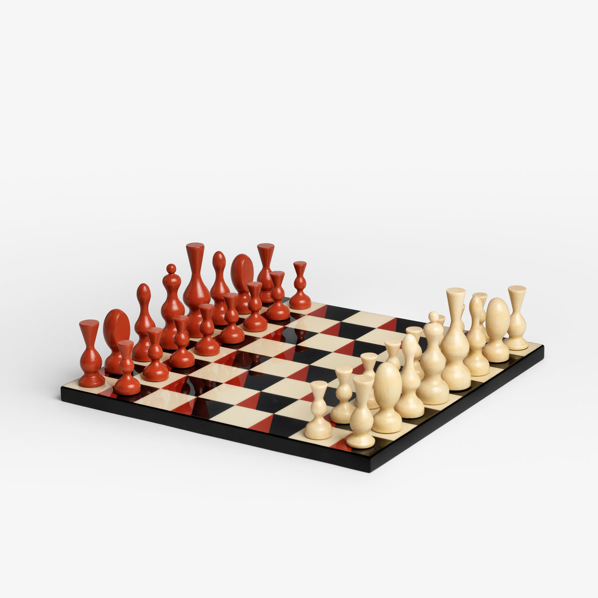 Surrealist chess set by Printworks, featuring a terracotta orange box with cream lettering and a checkered board with black, cream, and red squares and red-and-cream pawns, shown on a white background.