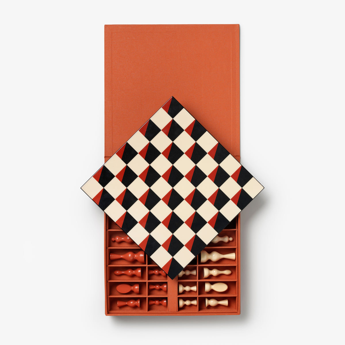 A chess game set in a terracotta-colored box, shown open with the lid tilted to reveal the board and chess pieces inside. The board features a black and cream diamond pattern, and the pieces are arranged in the compartments below.