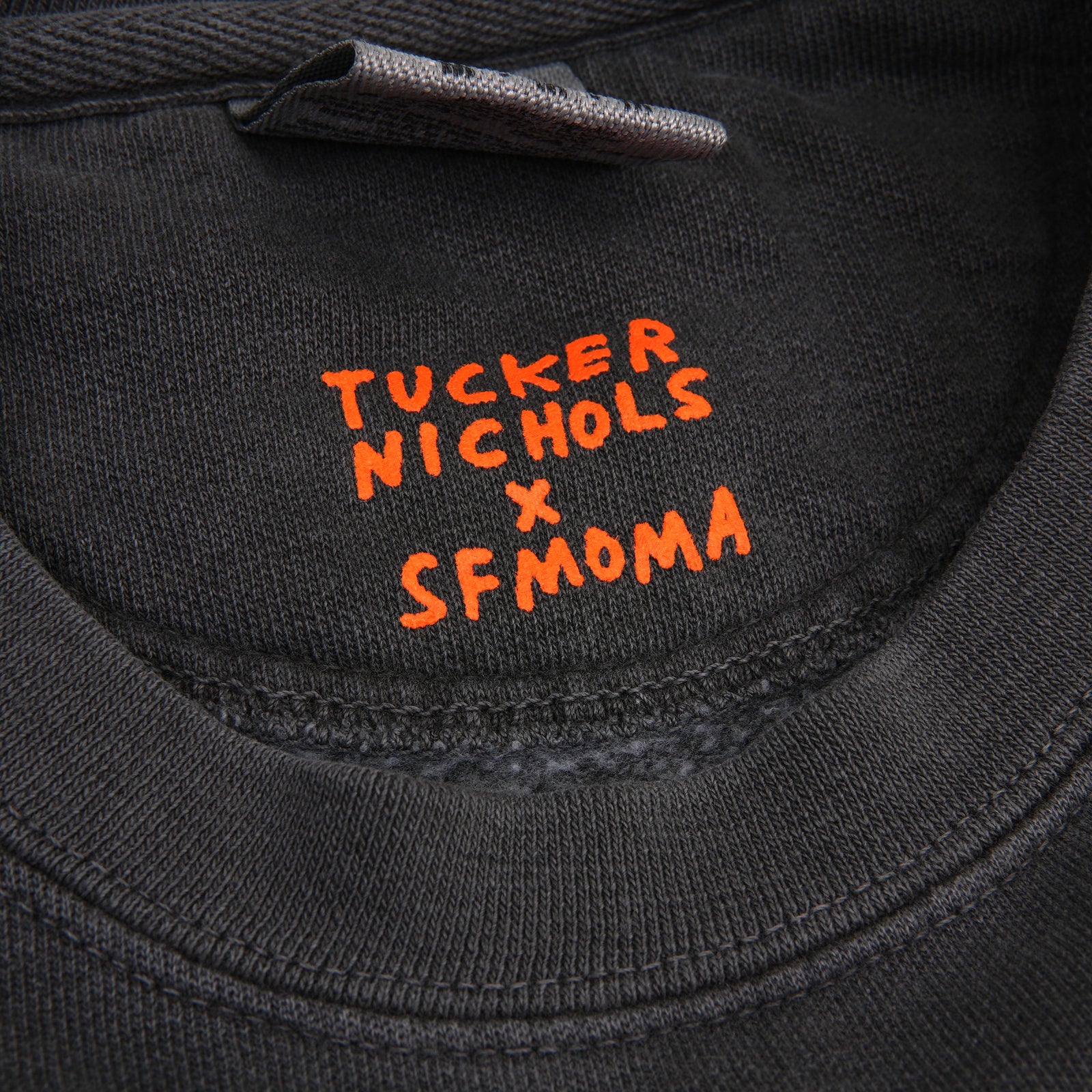 A dark gray crewneck sweatshirt with a distressed gray graphic on the chest that reads 'I FINISHED MY BURRITO IN SAN FRANCISCO' in black text.