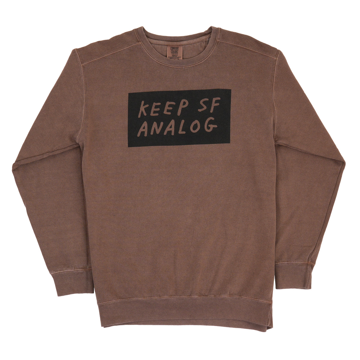 A brown ribbed crewneck sweatshirt featuring a black rectangular graphic on the chest with the text 'KEEP SF ANALOG' in a handwritten font, displayed flat against a white background.