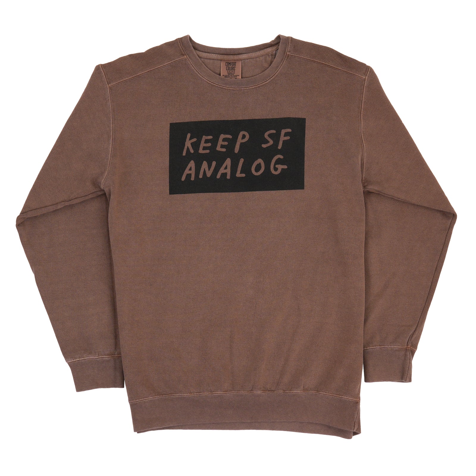 A brown ribbed crewneck sweatshirt featuring a black rectangular graphic on the chest with the text 'KEEP SF ANALOG' in a handwritten font, displayed flat against a white background.