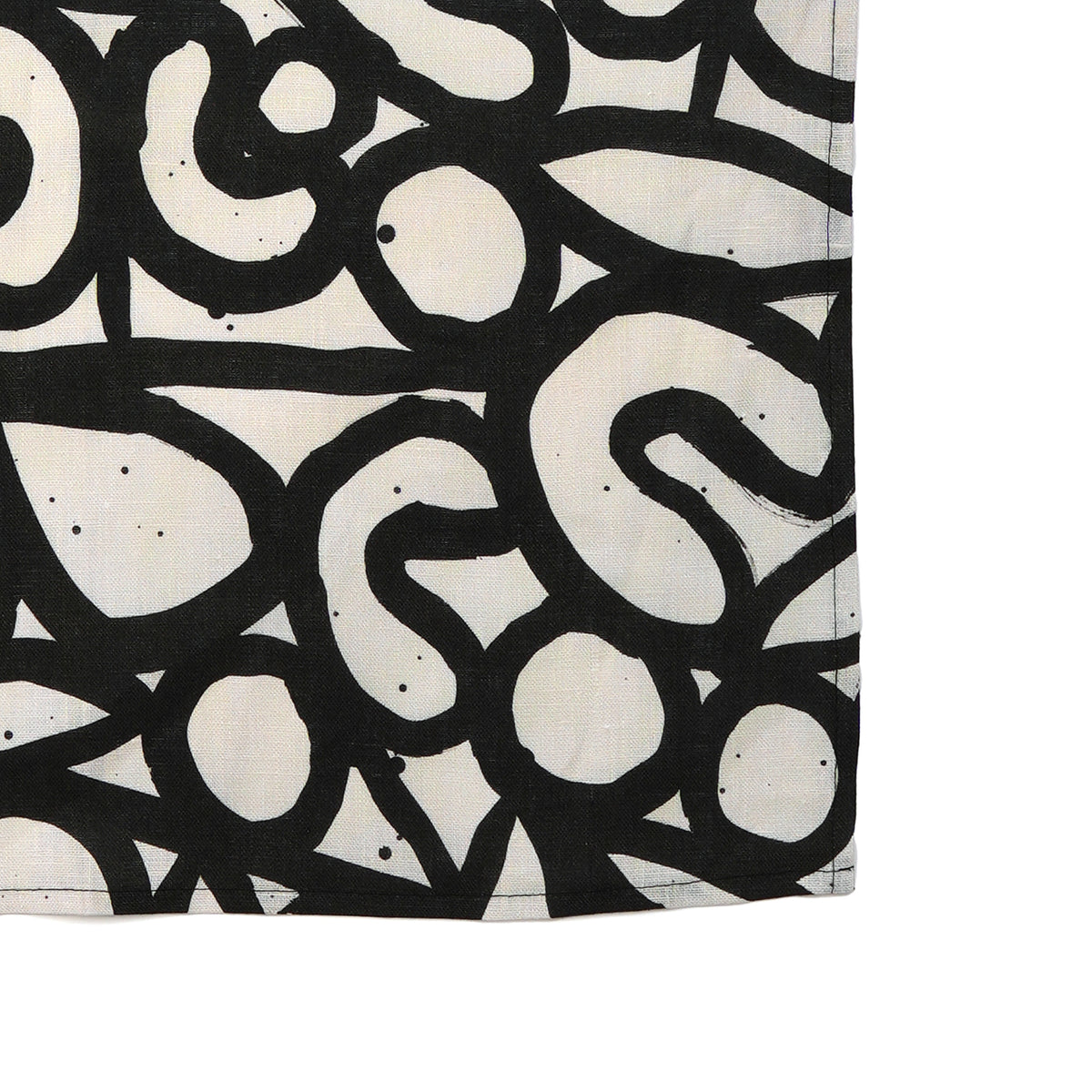 A rectangular tea towel, featuring an abstract black and off-white organic pattern on a plain white background.