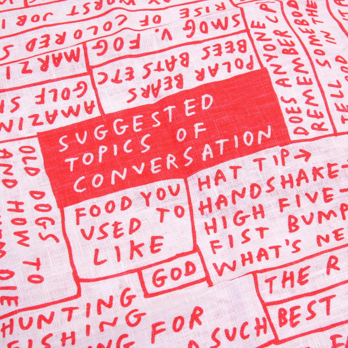 A close-up of a white fabric with red printed text and hand-drawn red boxes, featuring a central red box that reads 'SUGGESTED TOPICS OF CONVERSATION'.