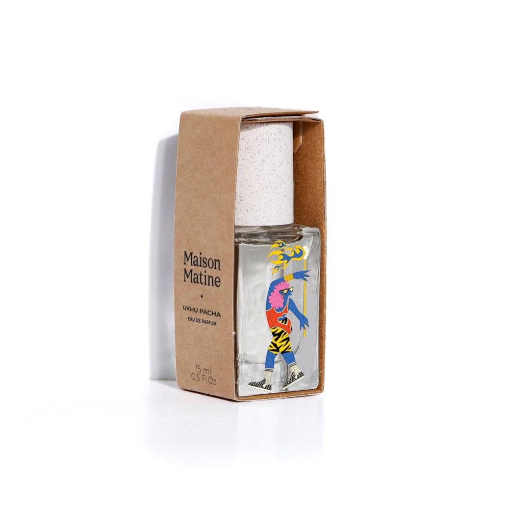 Maison Matine Parfum 15ml bottle in a clear glass container with a colorful abstract illustration, presented in a brown kraft paper sleeve on a white background.