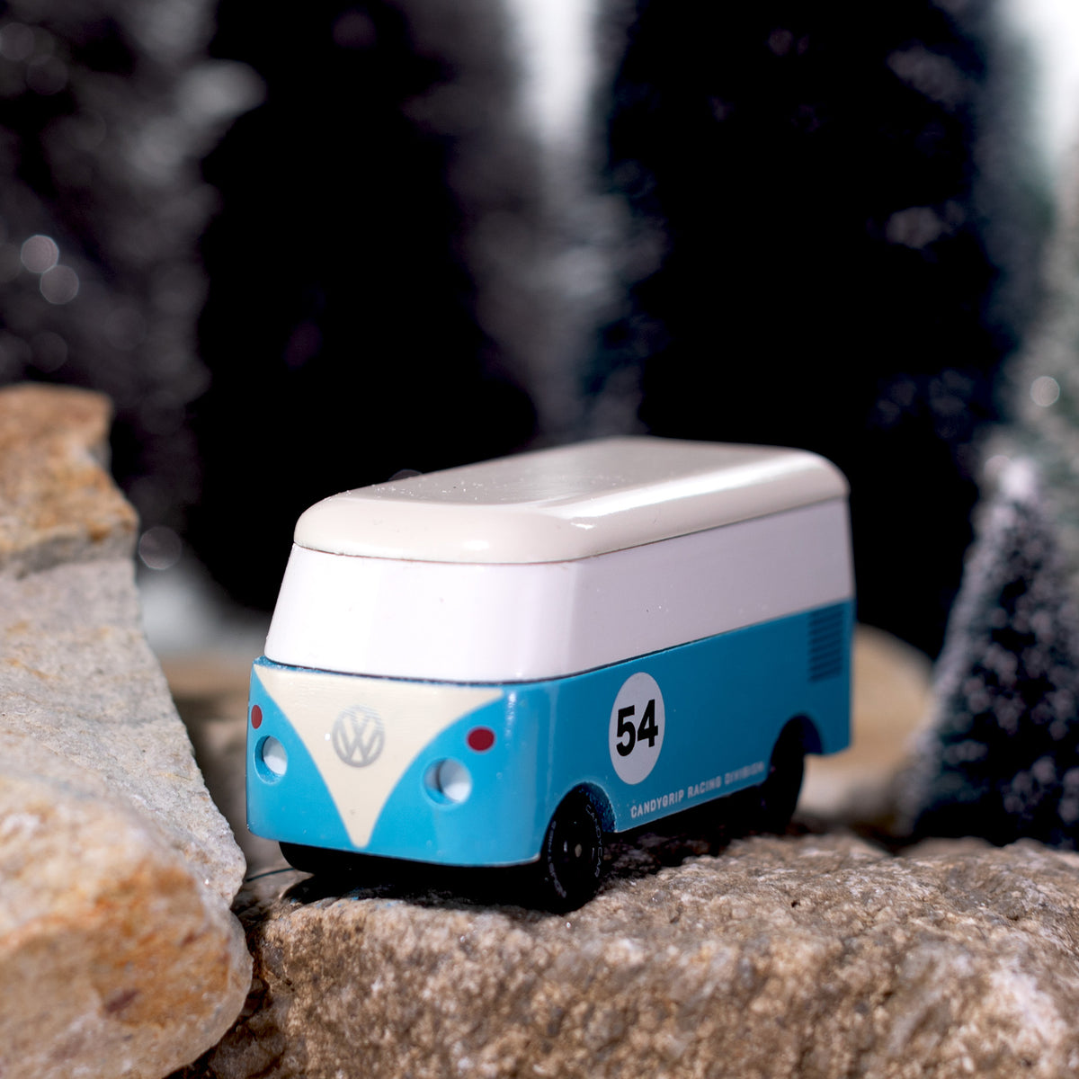 Toy van with a number 54 on a rock with a blurred natural background