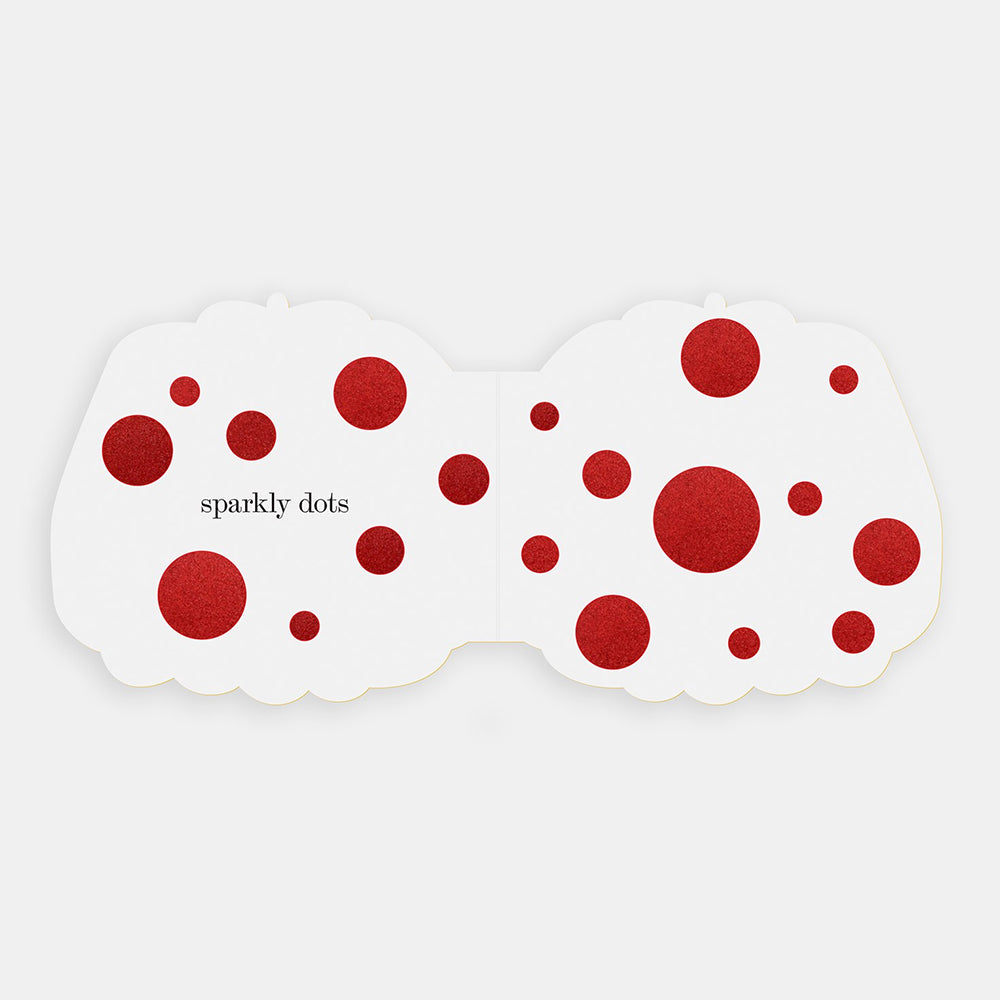 White interior spread with red glittery polka dots and the text 'sparkly dots' printed in black on the left side, shown against a light gray background.