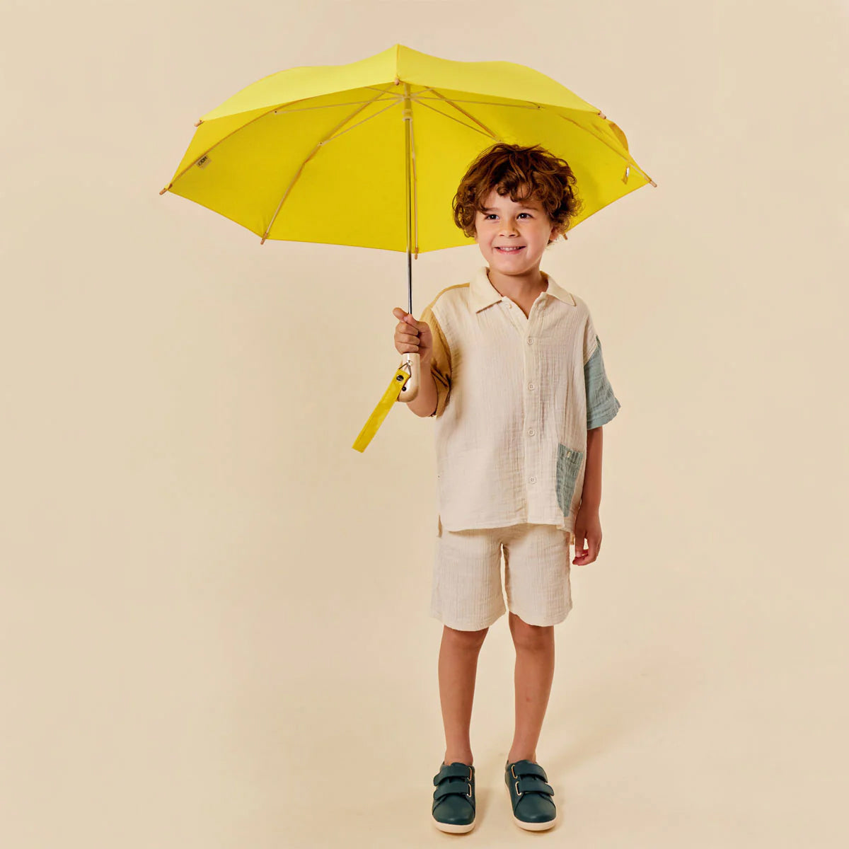 Yellow umbrella with a bird-shaped handle on a white background