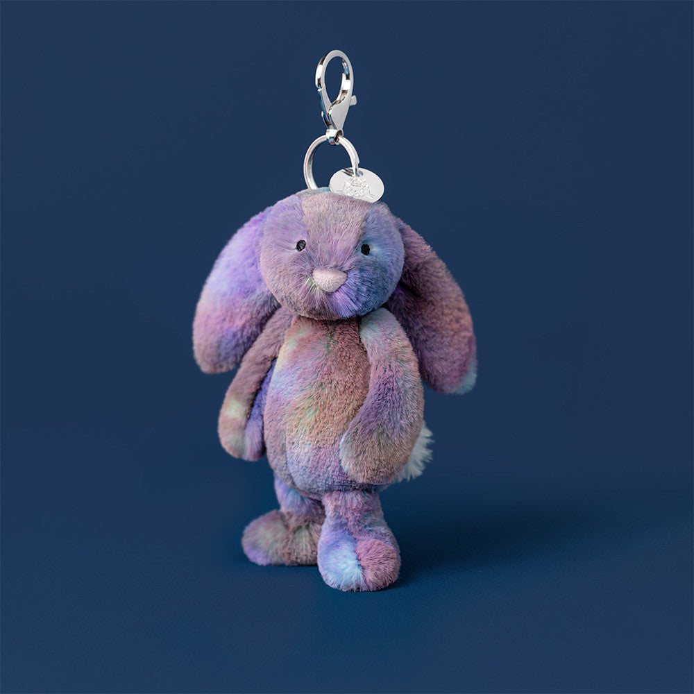 Plush bunny keychain with a tag on a dark blue background