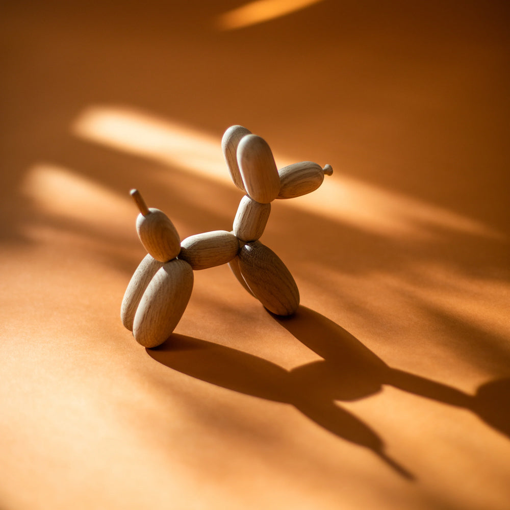 Wooden dog sculpture casting a shadow on an orange surface