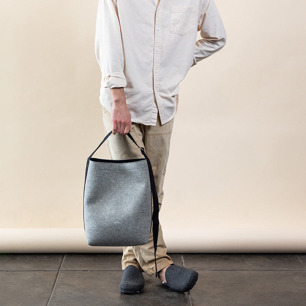 Model holding tote from strap.