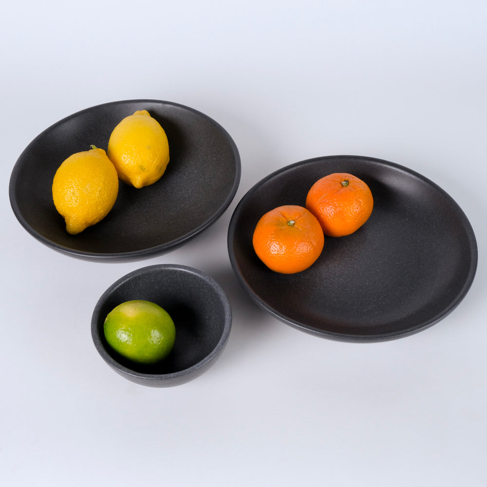 Group of ceramic bowls with fruit.