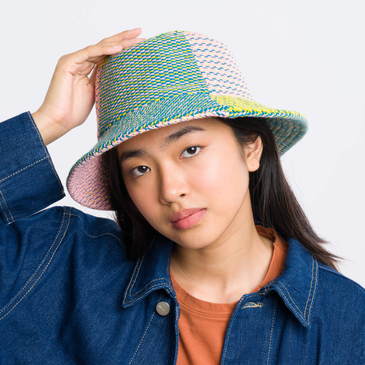 Person wearing a colorful bucket hat against a plain background