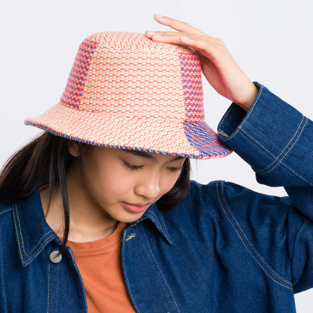 Person wearing a colorful bucket hat against a plain background