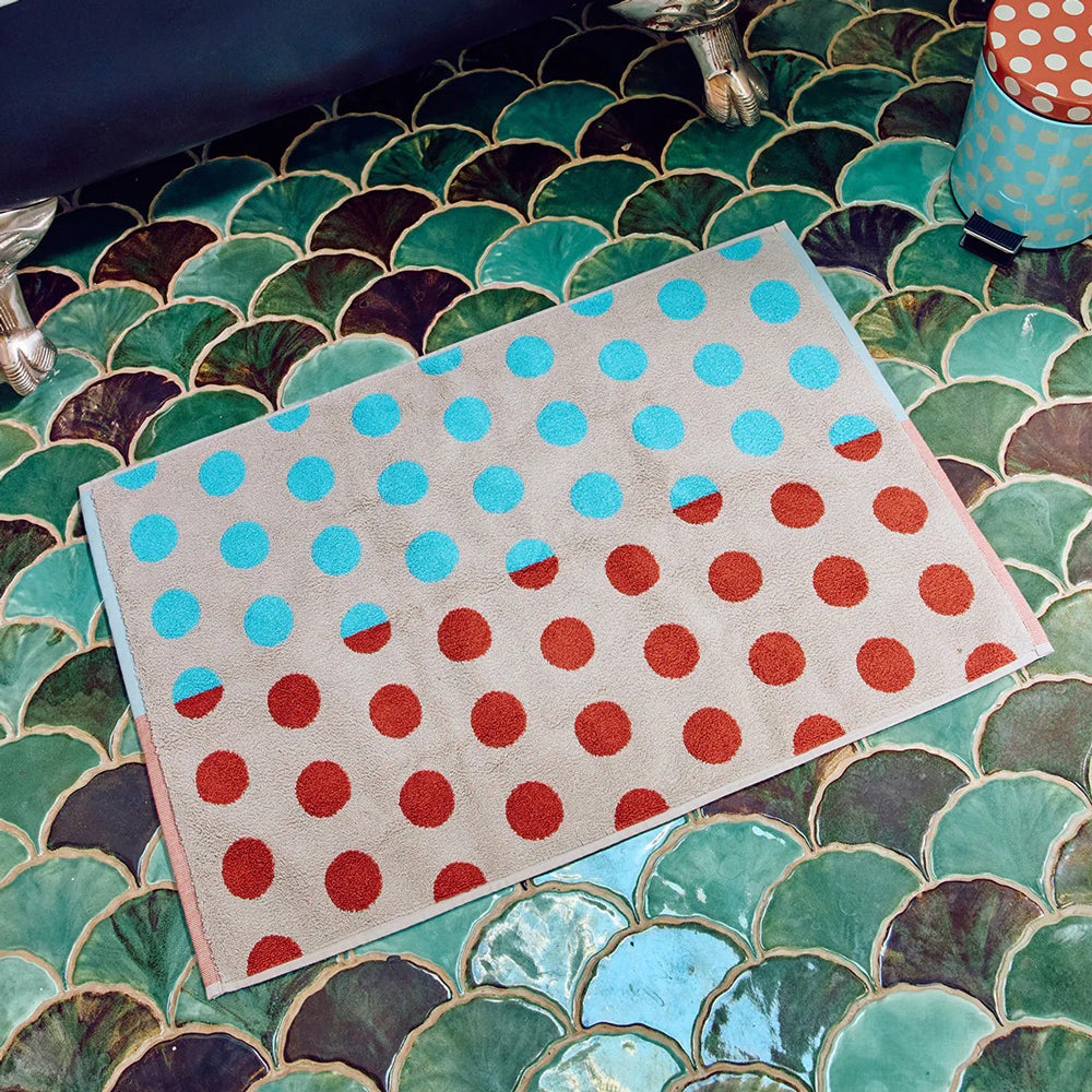 Polka dot bathmat on a mosaic tiled floor